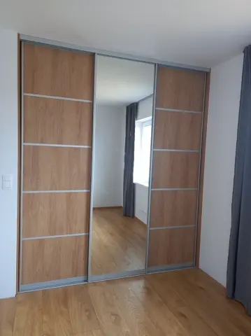 Posuvné dvere na mieru do spálne s kombinovanou výplňou dverí v dekore dub