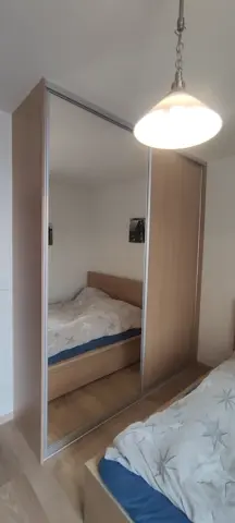 Šatníková skriňa na mieru do spálne, dvojdverová s kombinovanou výplňou dverí v dekore dub