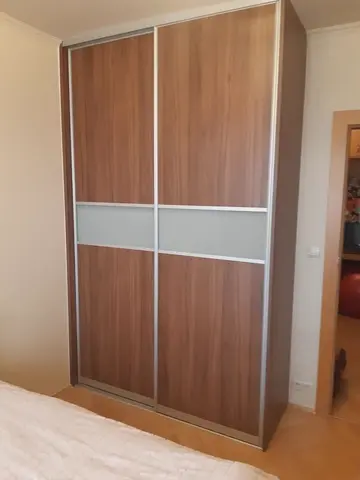 Šatníková skriňa na mieru do spálne, dvojdverová s kombinovanou výplňou dverí v dekore orech