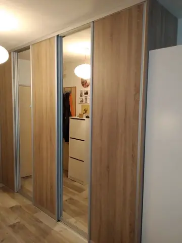 Vstavaná skriňa na mieru s kombinovanou výplňou dverí v dekore dub