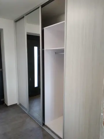 Vstavaná skriňa na mieru s kombinovanou výplňou dverí vo svetlom dekore javor