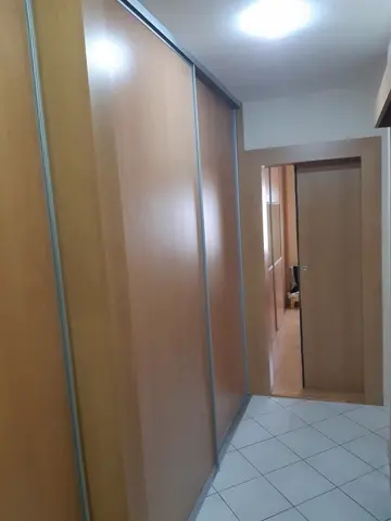 Vstavaná skriňa na mieru do chodby a predsiene s dverami v dekore buk