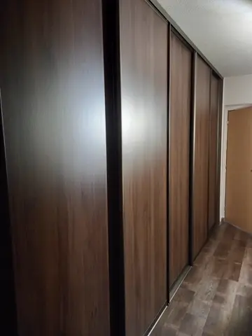 Vstavaná skriňa na mieru do chodby a predsiene s dverami v dekore orech
