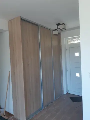 Vstavaná skriňa na mieru do chodby a predsiene s dverami v dekore dub