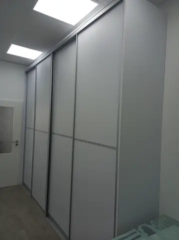 Vstavaná skriňa na mieru do chodby a predsiene s dverami v dekore dreva, biela