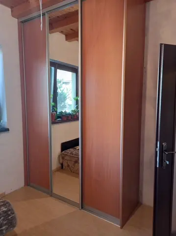 Vstavaná skriňa na mieru do spálne s kombinovanou výplňou dverí v dekore orech